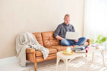 Man sitter i soffan och jobbar hemifrån