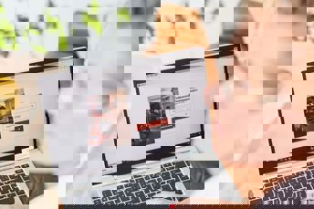 Kvinna sitter vid datorn och loggar in på företagsportalen