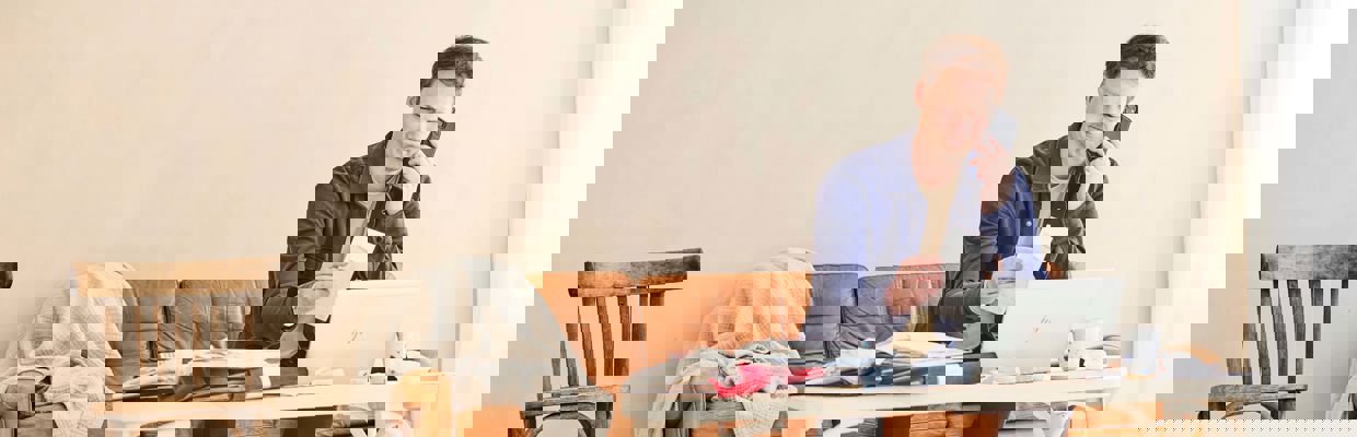 Man som sitter i soffan med massa kvitton runt sig