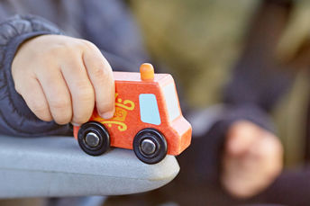 Bilden visar ett barn som leker med en leksaksbuss.