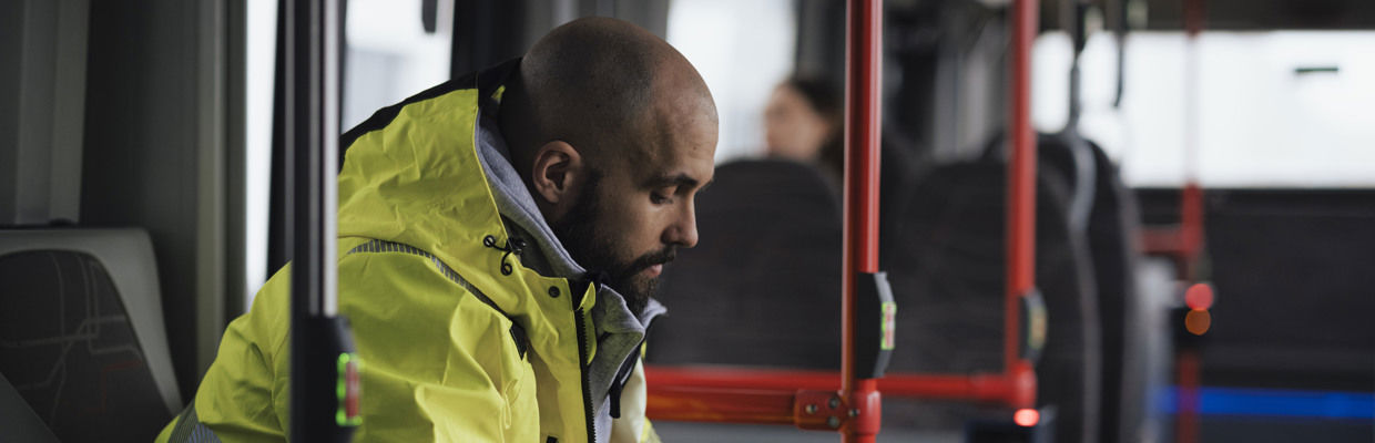 Resenär i varseljacka ombord på en buss.