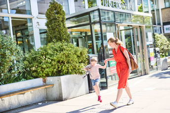 En mamma och en dotter som går skrattade hand i hand förbi Juneporten i Jönköping.